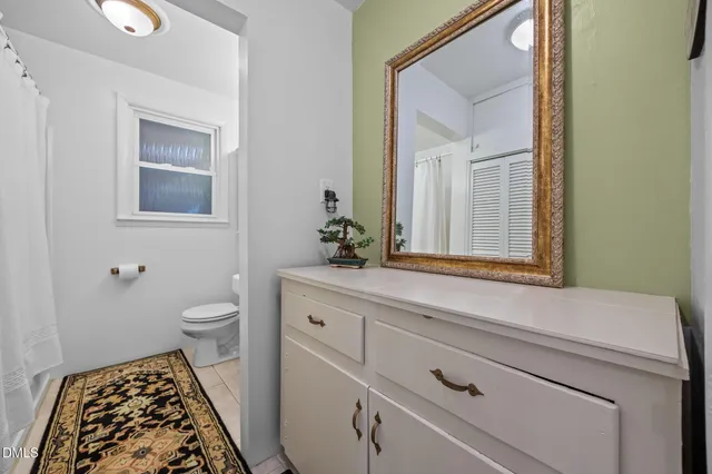 a bathroom with a toilet a sink and a mirror