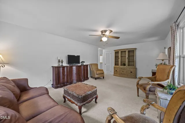 a living room with furniture a flat screen tv and kitchen view