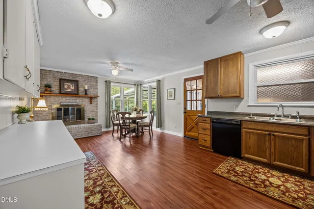 a living room with furniture a fireplace and kitchen view