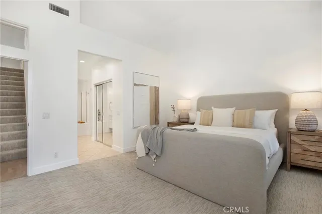 a bedroom with a large bed and a chandelier