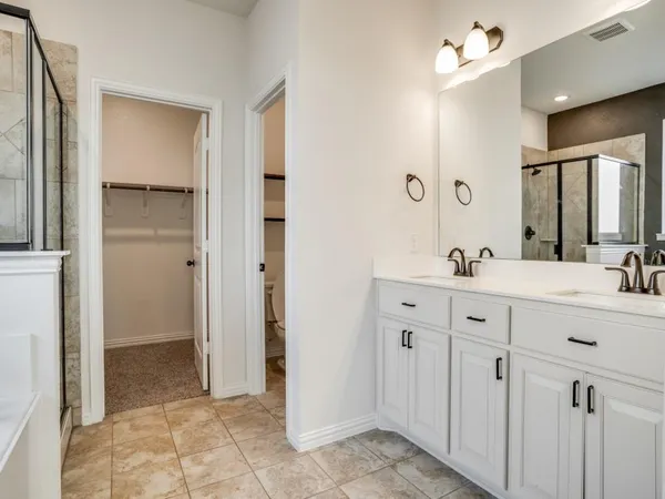 a spacious bathroom with a double vanity sink a mirror and a shower