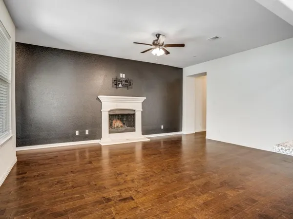 a view of an empty room with a fireplace and a window