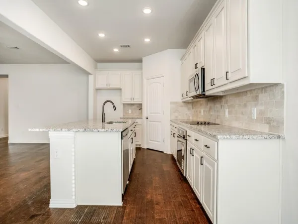 a kitchen with sink a stove and cabinets
