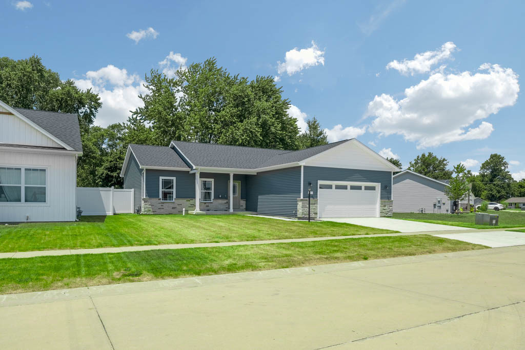 a front view of a house with a garden and trees