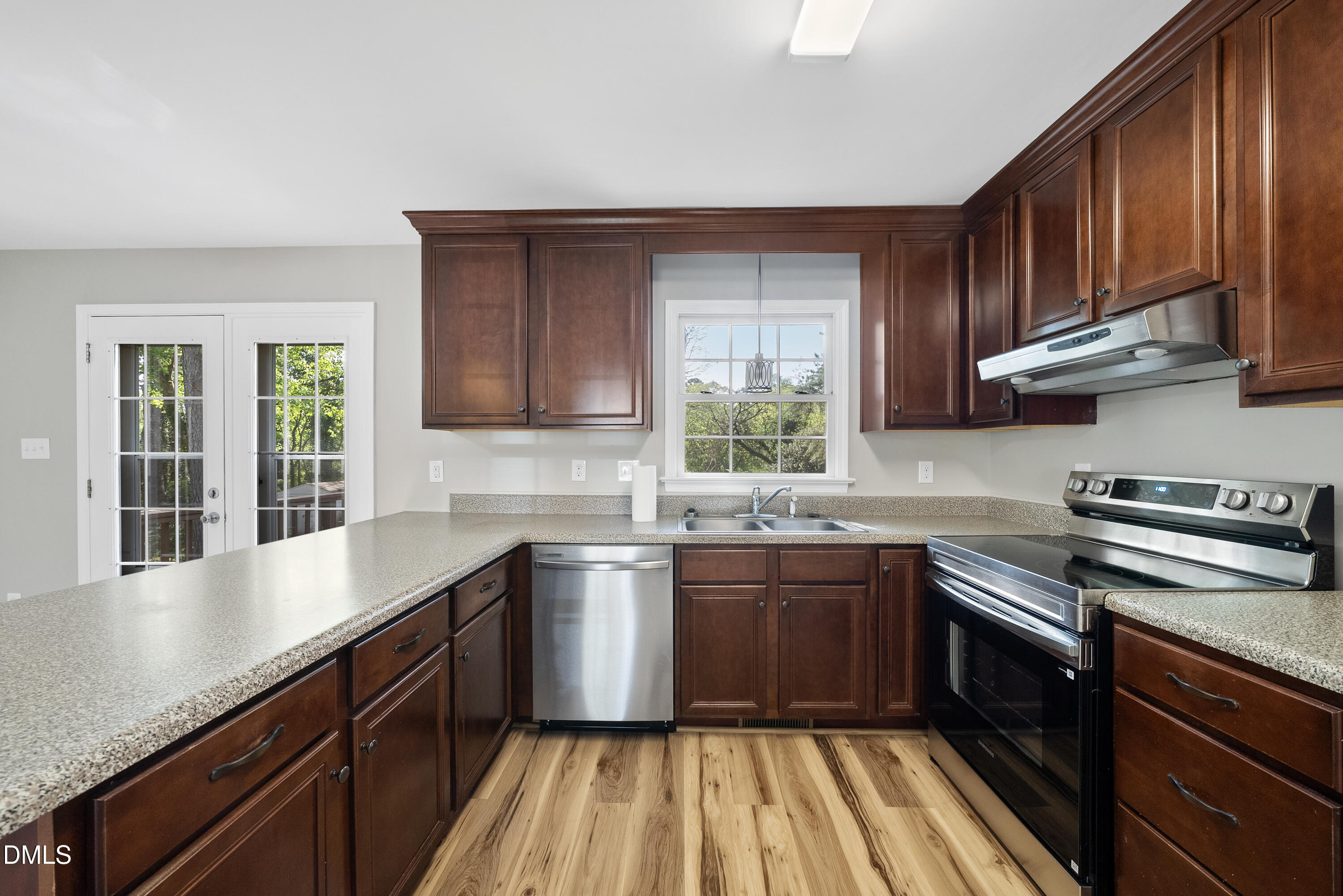 2123 Shenandoah Road Raleigh, NC 27603 - Photo 10 of 26 a kitchen with stainless steel appliances granite countertop wooden cabinets a stove top oven a sink and dishwasher with wooden floor