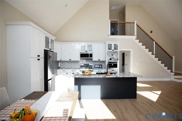 a bedroom with a bed a desk and chair with wooden floor