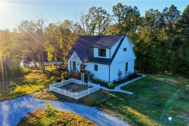 an aerial view of a house with a garden and lake view