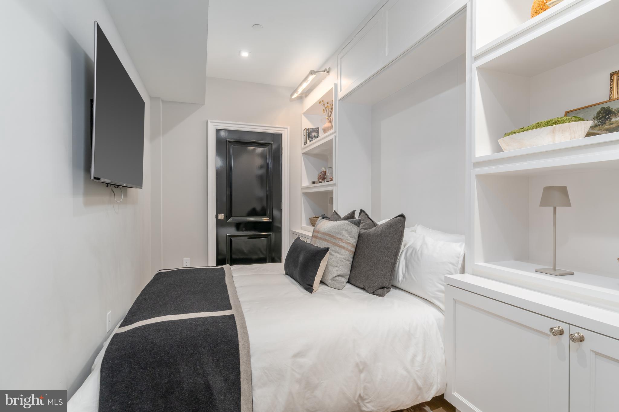 1639 35th Street Northwest Washington, DC 20007 - Photo 13 of 60 a bedroom with a bed and a flat tv screen on the dresser