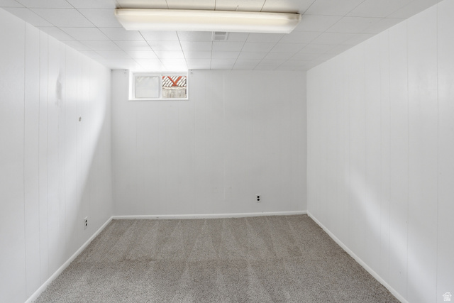 774 37th Street South Ogden, UT 84403 - Photo 22 of 47 Spacious room featuring light gray carpeting, crisp white paneled walls, a drop ceiling with integrated lighting, and a single window