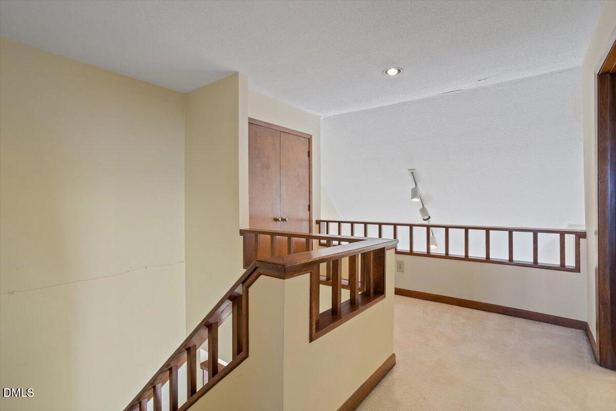 4329 Southwind Drive Raleigh, NC 27613 - Photo 20 of 30 a view of staircase with lots of frames on wall and a window