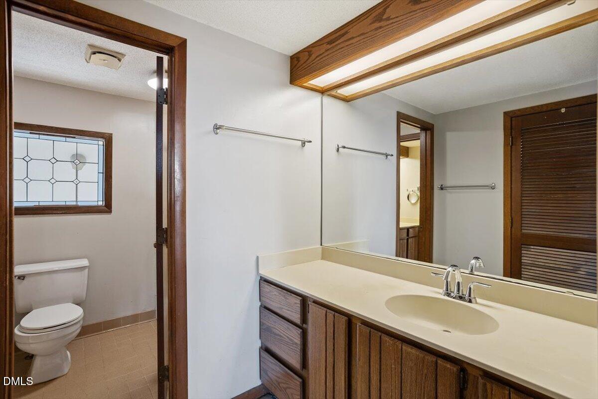 4329 Southwind Drive Raleigh, NC 27613 - Photo 23 of 30 a bathroom with a granite countertop sink toilet and shower