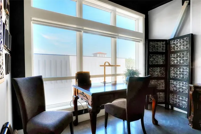 a view of a workspace with furniture and a window