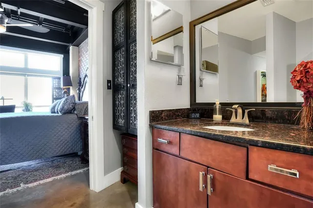 a bathroom with a granite countertop sink and a mirror