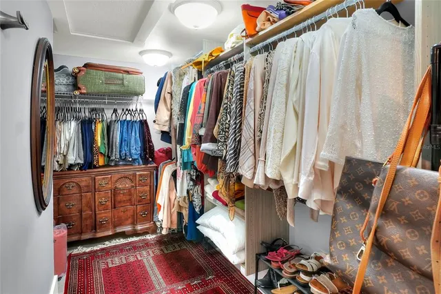 a view of walk in closet with clothes and shoes