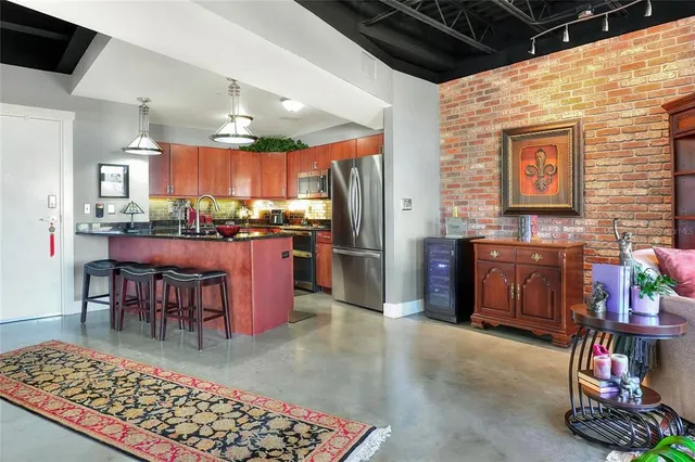 a kitchen with lots of wooden cabinets appliances and furniture