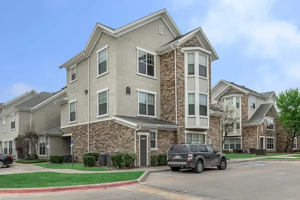 a front view of a residential apartment building with a yard