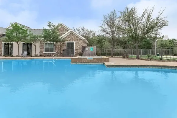 a view of a house with pool and wooden fence