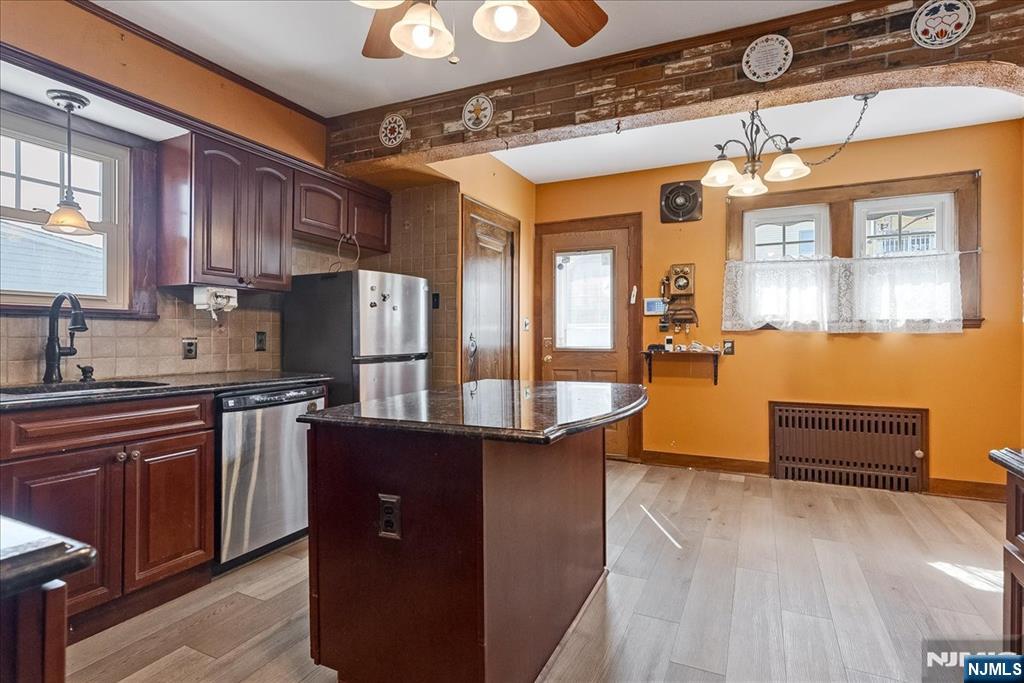 52 Manner Avenue Garfield, NJ 07026 - Photo 11 of 23 a kitchen with stainless steel appliances granite countertop a refrigerator a sink dishwasher a stove and white countertops with wooden floor