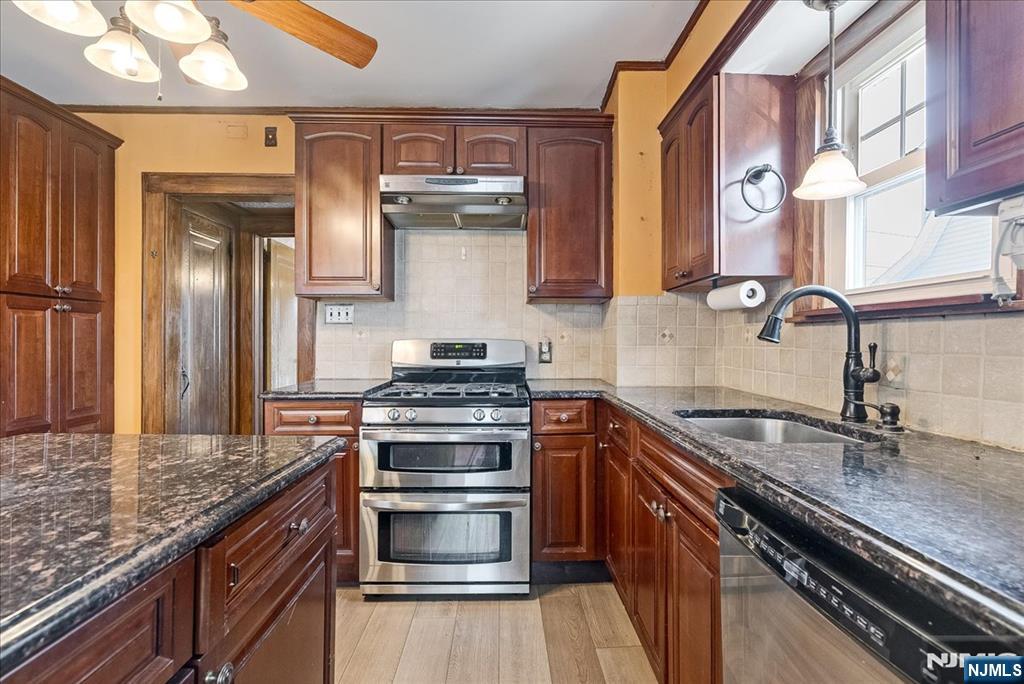52 Manner Avenue Garfield, NJ 07026 - Photo 12 of 23 a kitchen with stainless steel appliances granite countertop a sink stove and refrigerator