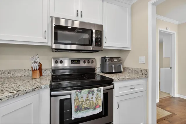 a kitchen with granite countertop a stove and a microwave