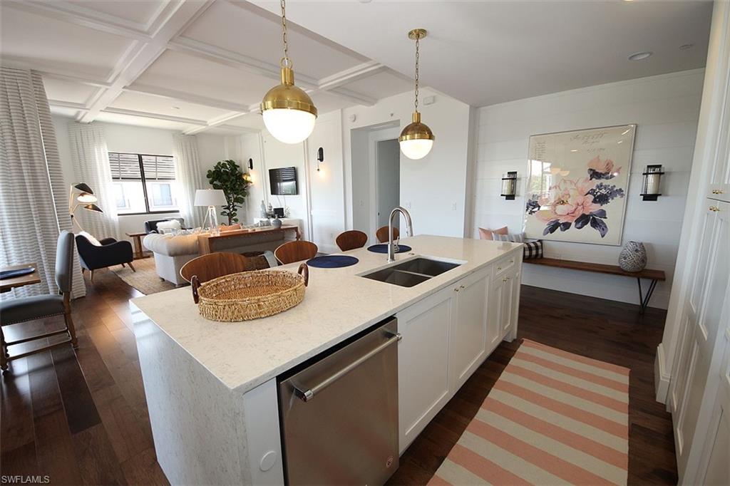 1035 3rd Avenue South, Unit 411 Naples, FL 34102 - Photo 48 of 49 a large living room with stainless steel appliances kitchen island granite countertop furniture and a chandelier