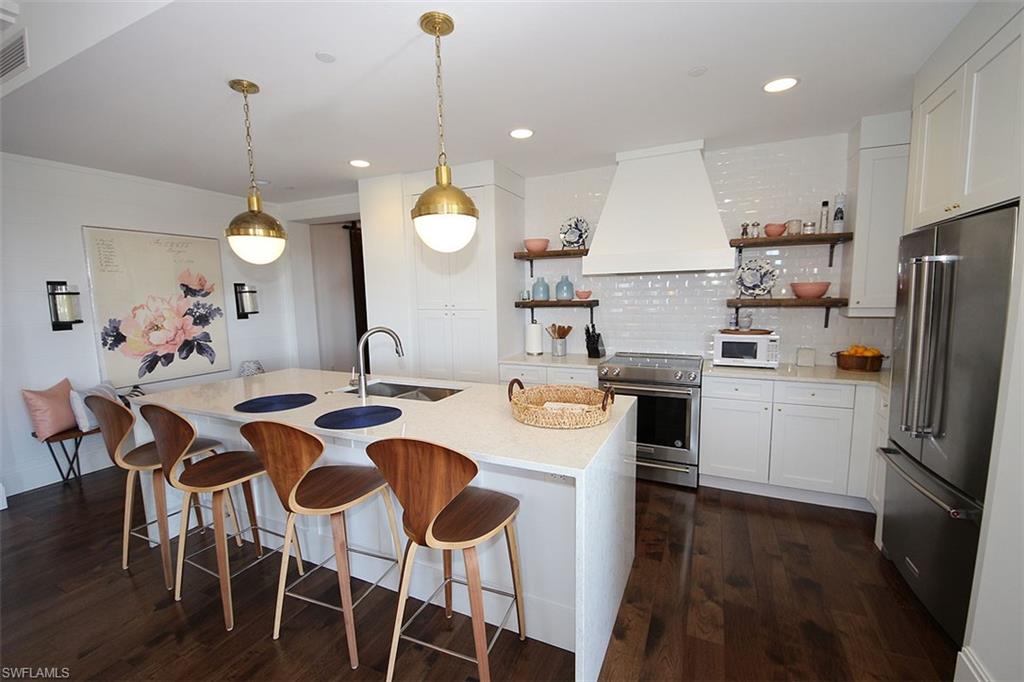 1035 3rd Avenue South, Unit 411 Naples, FL 34102 - Photo 12 of 49 a kitchen with refrigerator a sink dining table and chairs
