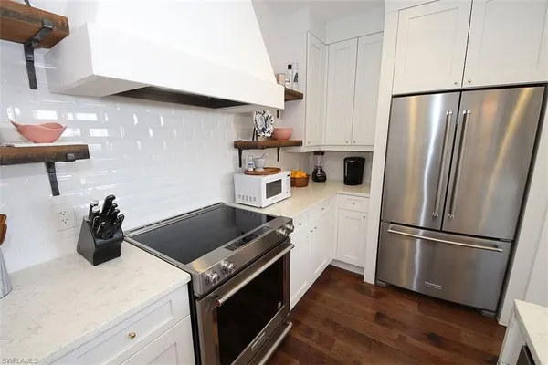 a kitchen with refrigerator a sink dining table and chairs