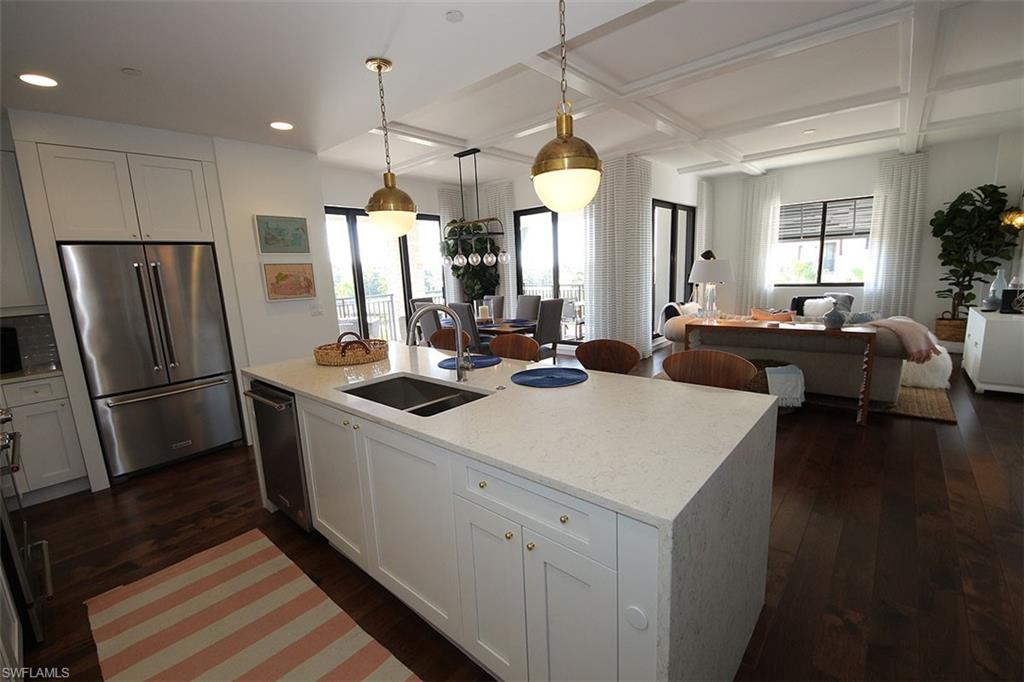 1035 3rd Avenue South, Unit 411 Naples, FL 34102 - Photo 49 of 49 a kitchen with kitchen island a refrigerator stove and sink