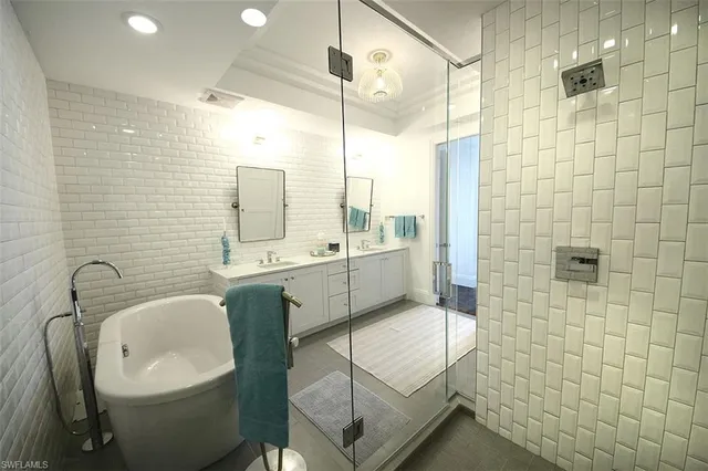 a bathroom with a double vanity sink a mirror and a bathtub