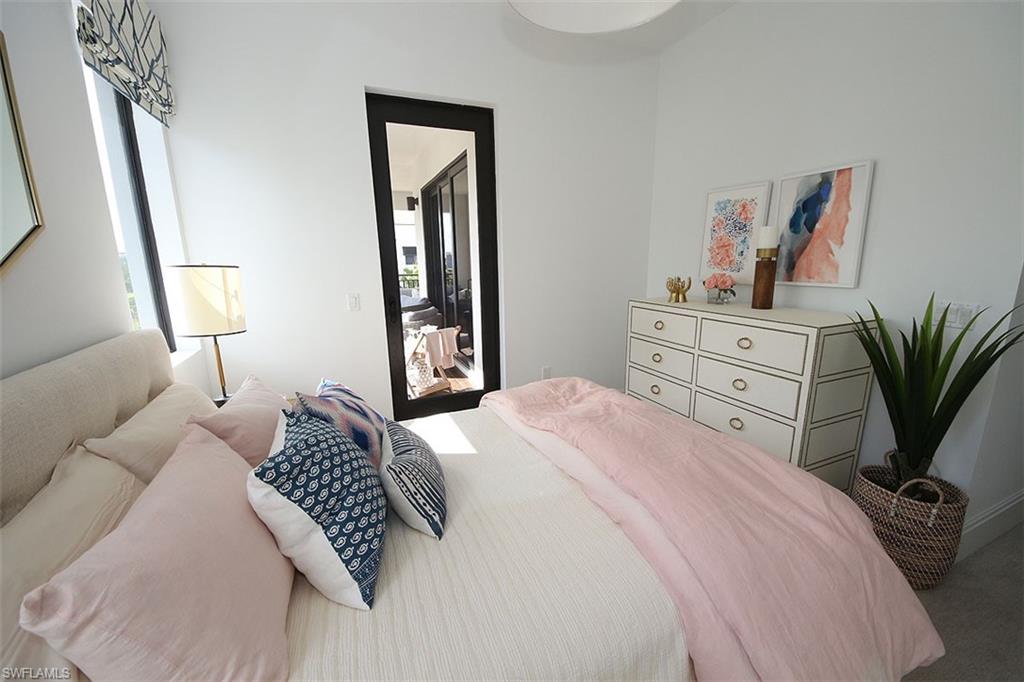 1035 3rd Avenue South, Unit 411 Naples, FL 34102 - Photo 21 of 49 a bedroom with a bed potted plant with the mirror