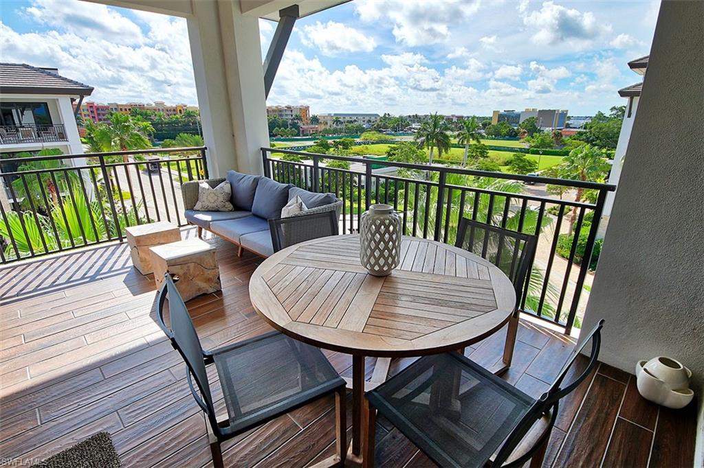 1035 3rd Avenue South, Unit 411 Naples, FL 34102 - Photo 32 of 49 a view of a balcony with a table and chairs