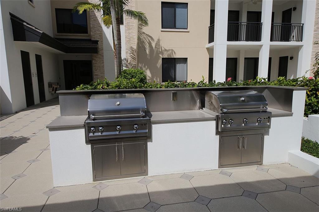1035 3rd Avenue South, Unit 411 Naples, FL 34102 - Photo 39 of 49 a kitchen with granite countertop a stove and a sink