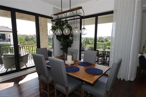 a dining room with furniture a chandelier and wooden floor