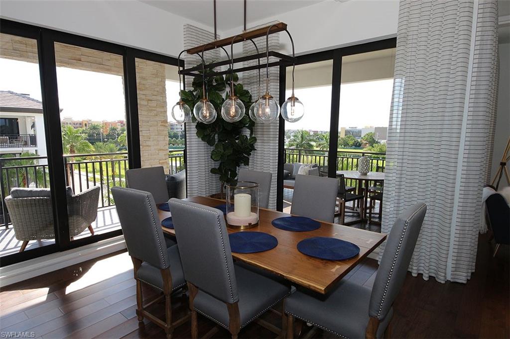 1035 3rd Avenue South, Unit 411 Naples, FL 34102 - Photo 9 of 49 a dining room with furniture a chandelier and wooden floor