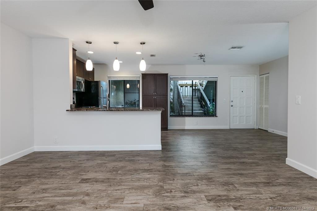 800 Northwest Fork Road, Unit 86 Stuart, FL 34994 - Photo 12 of 40 wooden floor in an empty room with a kitchen