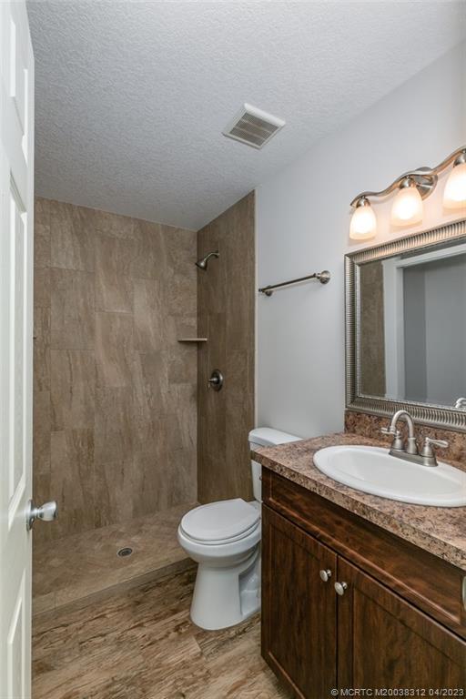 800 Northwest Fork Road, Unit 86 Stuart, FL 34994 - Photo 17 of 40 a bathroom with a granite countertop sink toilet a mirror and shower