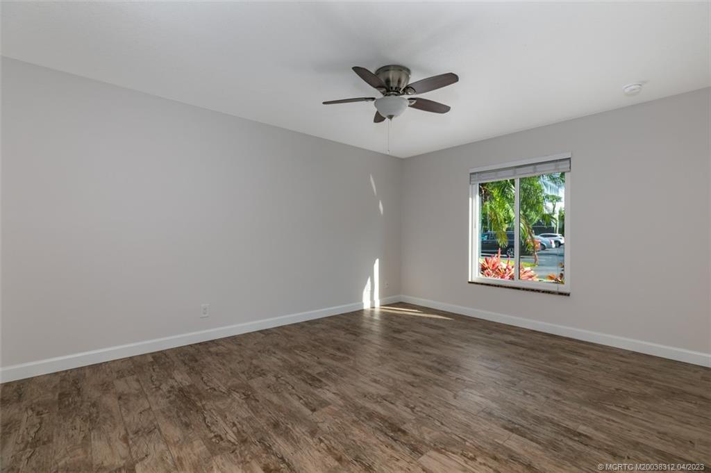800 Northwest Fork Road, Unit 86 Stuart, FL 34994 - Photo 18 of 40 a view of an empty room with wooden floor and a window