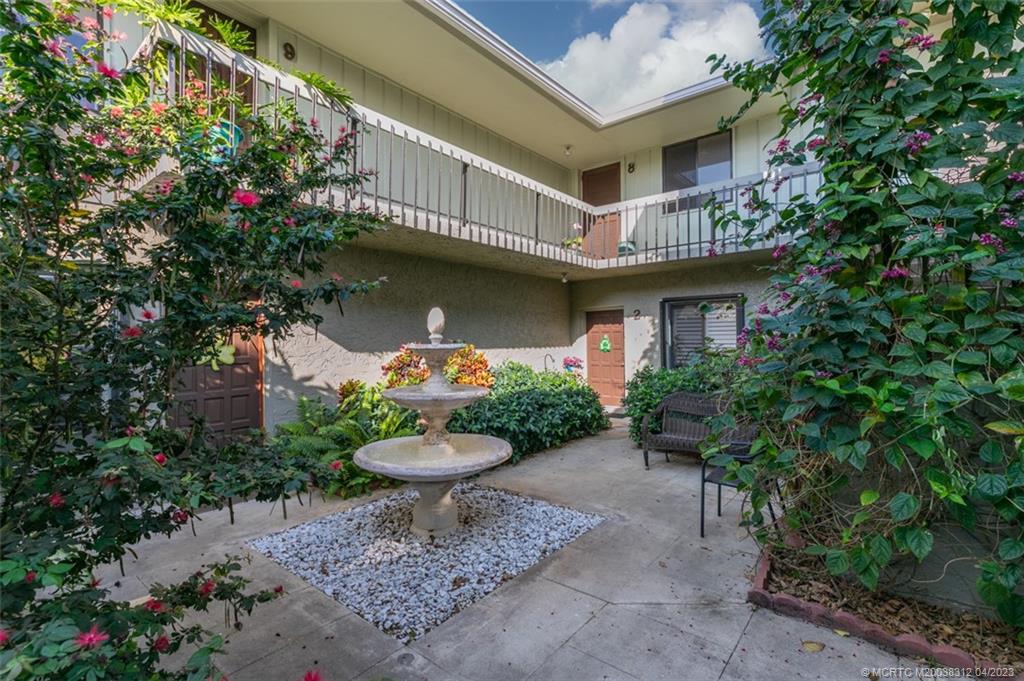 800 Northwest Fork Road, Unit 86 Stuart, FL 34994 - Photo 3 of 40 a yellow and red house with potted plants
