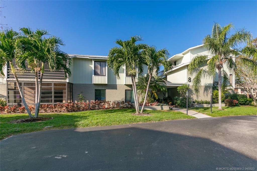 800 Northwest Fork Road, Unit 86 Stuart, FL 34994 - Photo 35 of 40 a view of a house with a yard and palm trees