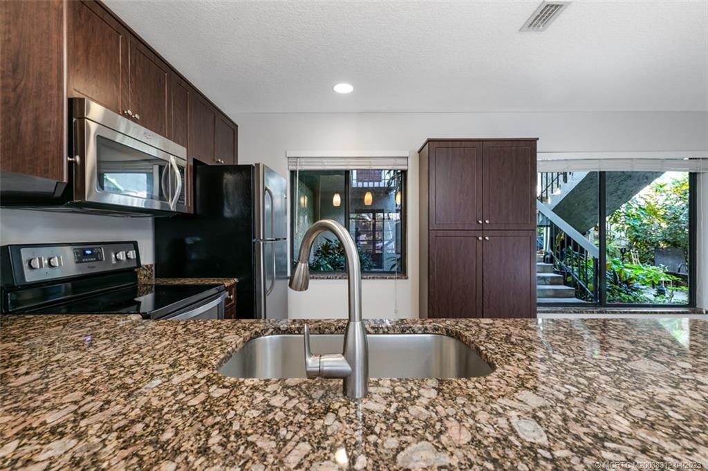 800 Northwest Fork Road, Unit 86 Stuart, FL 34994 - Photo 8 of 40 a kitchen with stainless steel appliances granite countertop a refrigerator and a sink