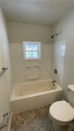 a white toilet sitting next to a bath tub