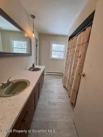 a bathroom with a sink a bathtub and a window