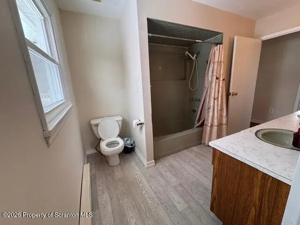 a hallway with sliding door and wooden floor