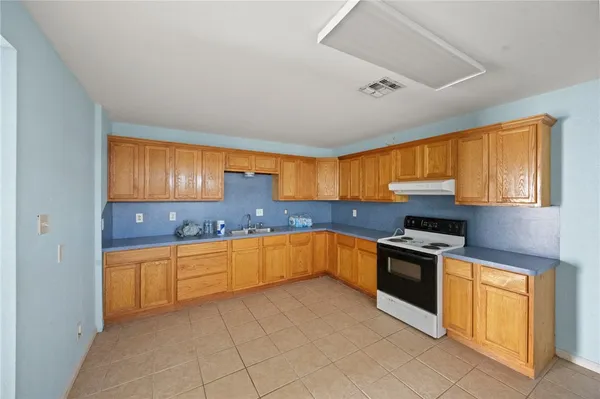 a kitchen with stainless steel appliances granite countertop a stove sink and cabinets