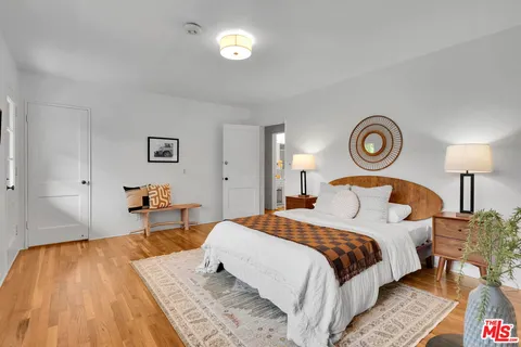 a bedroom with a bed and a lamp on dresser