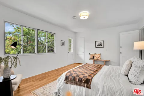 a bedroom with a bed and a large window