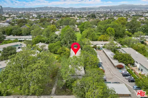 an aerial view of residential houses with outdoor space and trees