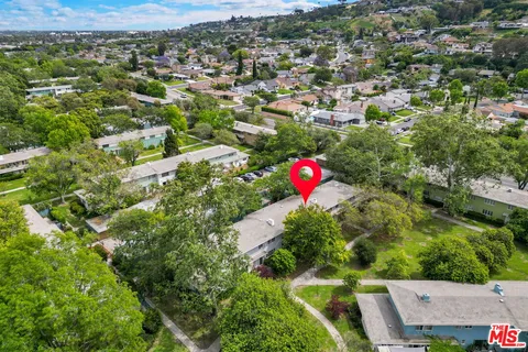 an aerial view of residential houses with outdoor space and trees