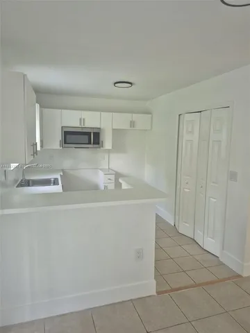 a close view of a sink a stove a refrigerator and a coffee table in a kitchen