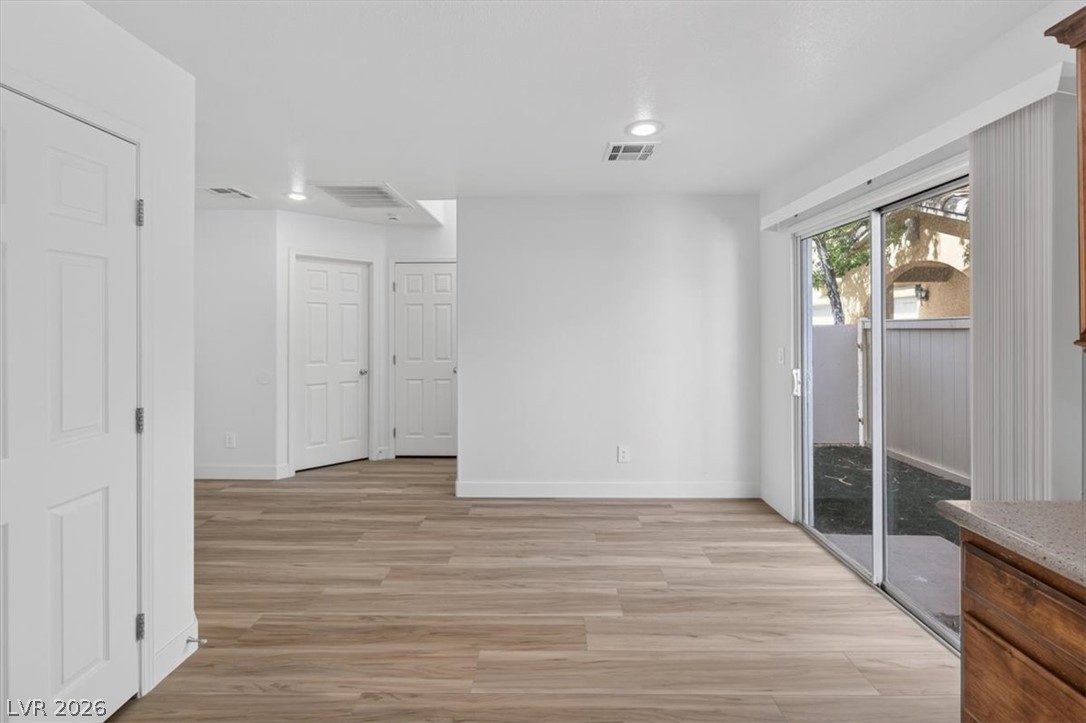 552 Albacate Street Henderson, NV 89015 - Photo 16 of 40 Luminous living area showcasing modern wood-look flooring and convenient sliding glass doors to outdoor space.